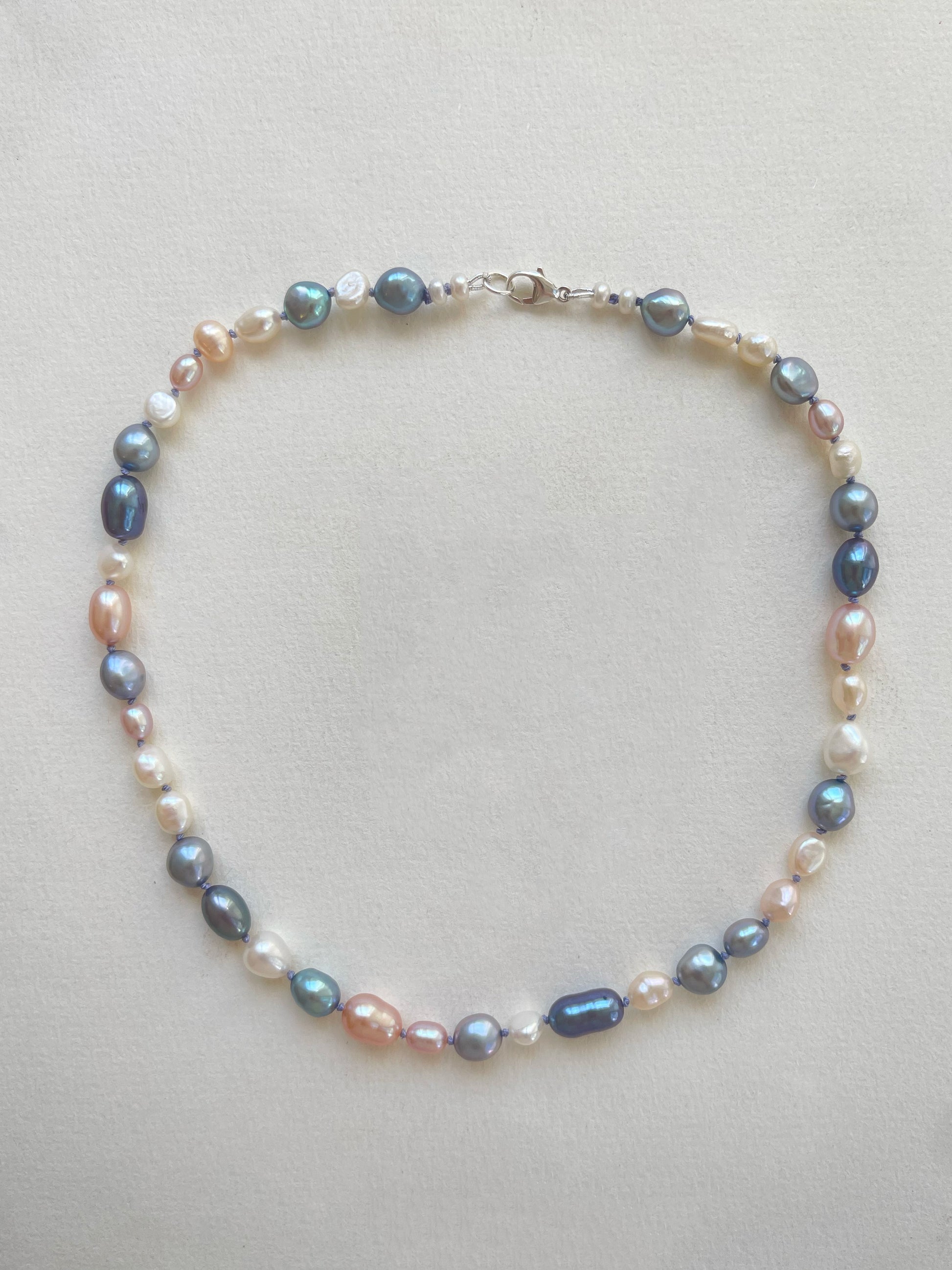 Multicolour pearls - pink, blue and white strung and knotted onto blue silk thread