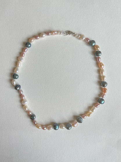 Multicoloured pearl necklace on a light background
