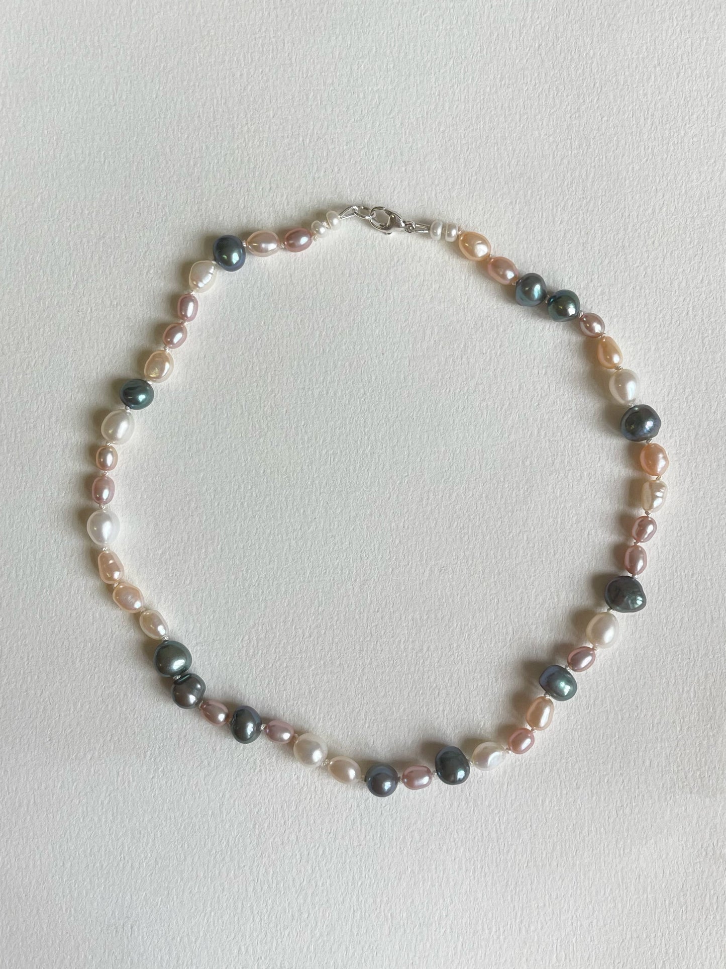 Multicoloured pearl necklace on a light background