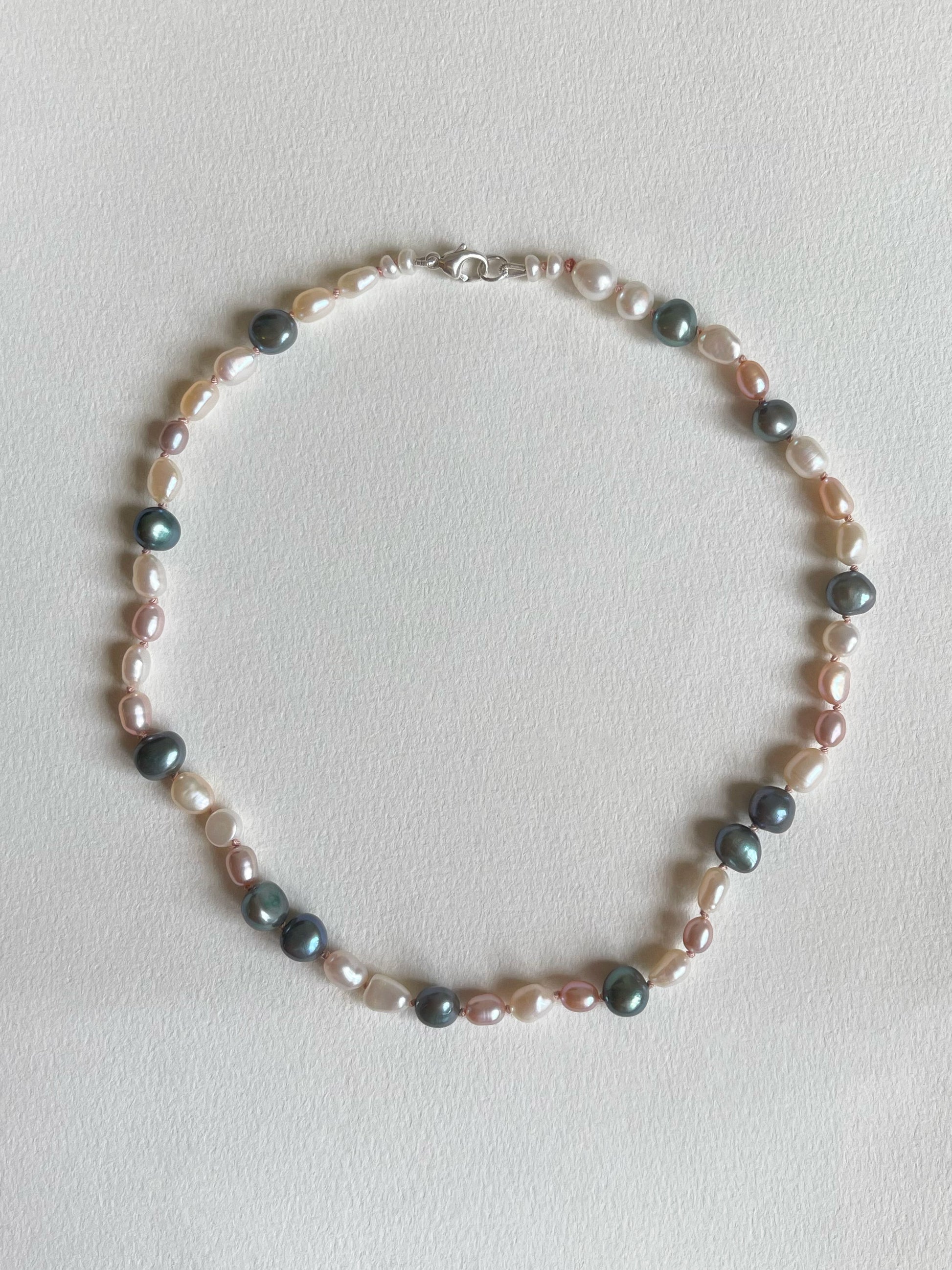 Multicoloured pearl necklace on a light background