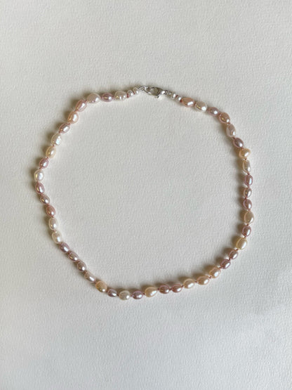 Pink and white pearl necklace on a light background