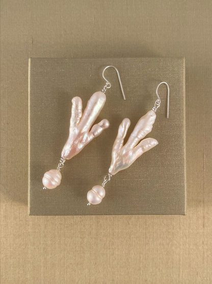 Pair of pearl earrings on a green background